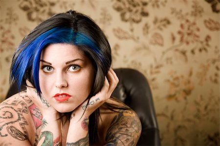 simsearch:400-05054627,k - Pretty young woman with many tattoos in a leather chair Stock Photo - Budget Royalty-Free & Subscription, Code: 400-04038960