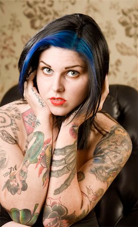 simsearch:400-05054627,k - Pretty young woman with many tattoos in a leather chair Stock Photo - Budget Royalty-Free & Subscription, Code: 400-04038961