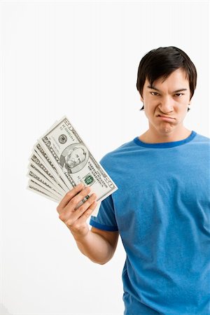 photographic portraits poor people - Asian young man holding money with disgust on his face. Stock Photo - Budget Royalty-Free & Subscription, Code: 400-04039865