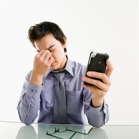 simsearch:400-04186486,k - Asian businessman rubbing his tired eyes his pda cellphone. Stock Photo - Budget Royalty-Free & Subscription, Code: 400-04039915