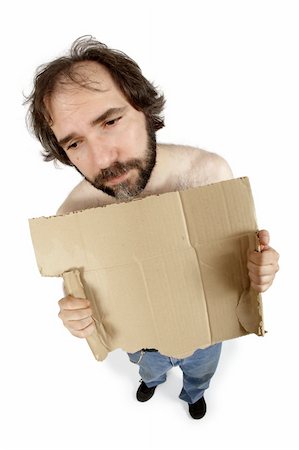 A homeless man clutching a torn cardboard sign, filled with anxiety and hopelessness.  Add your own message.  Shot with fish-eye lens - focus on face. Stock Photo - Budget Royalty-Free & Subscription, Code: 400-04030458