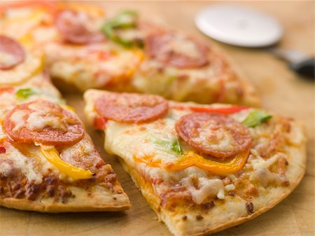 simsearch:400-04532905,k - CLose up of Pepperoni and Pepper Pizza with a Pizza Cutter Photographie de stock - Aubaine LD & Abonnement, Code: 400-04031504