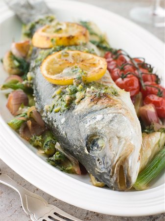 simsearch:400-04031652,k - Plate of Whole Roasted Sea Bass with Fennel Lemon Cherry Vine Tomatoes and Salsa Verde Stock Photo - Budget Royalty-Free & Subscription, Code: 400-04031525