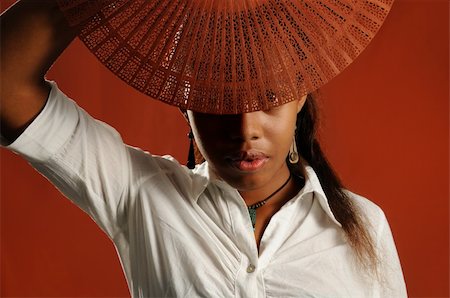 simsearch:400-04542798,k - Portrait of young african fashion female covering face with a fan Photographie de stock - Aubaine LD & Abonnement, Code: 400-04032174