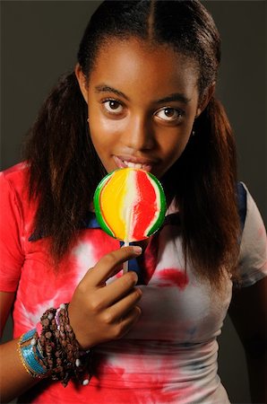 simsearch:400-07920877,k - Portrait of young african girl eating a lollipop with happy expression Stock Photo - Budget Royalty-Free & Subscription, Code: 400-04032175