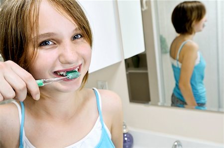 simsearch:400-06327889,k - Young girl brushing her teeth in a bathroom Photographie de stock - Aubaine LD & Abonnement, Code: 400-04032201