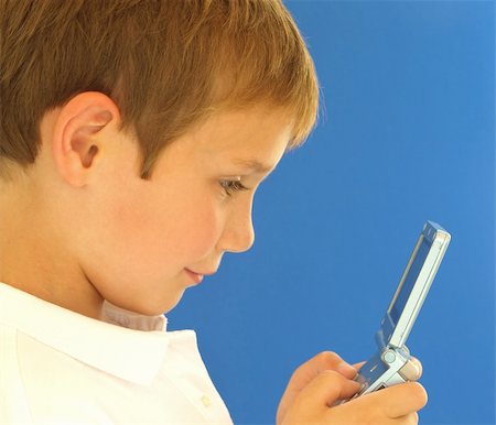 young boy playing a handheld video game Stock Photo - Budget Royalty-Free & Subscription, Code: 400-04033073