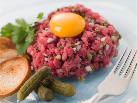steak tartare - Steak Tartare with Cornichons, Croutons and an Egg Yolk Stock Photo - Budget Royalty-Free & Subscription, Code: 400-04033812