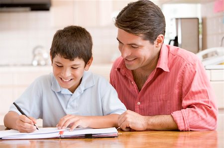 simsearch:400-04044122,k - Man helping young boy in kitchen doing homework and smiling Stock Photo - Budget Royalty-Free & Subscription, Code: 400-04044004