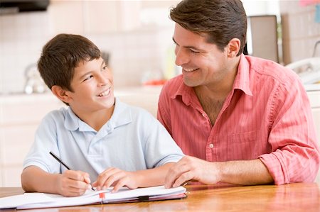 simsearch:400-04044122,k - Man helping young boy in kitchen doing homework and smiling Stock Photo - Budget Royalty-Free & Subscription, Code: 400-04044005