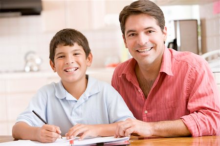 simsearch:400-04044122,k - Man helping young boy in kitchen doing homework and smiling Stock Photo - Budget Royalty-Free & Subscription, Code: 400-04044006