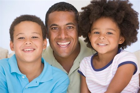 Man and two young children sitting in living room smiling Stock Photo - Budget Royalty-Free & Subscription, Code: 400-04044014