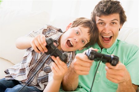 simsearch:400-05315413,k - Man and young boy with video game controllers smiling Fotografie stock - Microstock e Abbonamento, Codice: 400-04044038