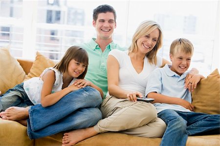 simsearch:400-04045202,k - Family sitting in living room with remote control smiling Stock Photo - Budget Royalty-Free & Subscription, Code: 400-04044047