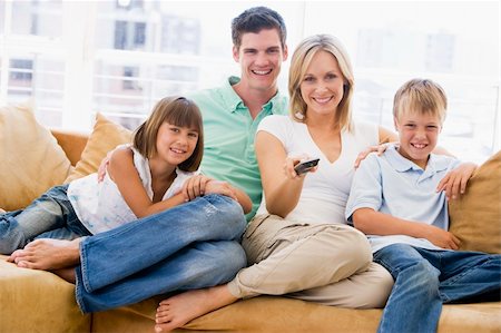 simsearch:400-04045202,k - Family sitting in living room with remote control smiling Stock Photo - Budget Royalty-Free & Subscription, Code: 400-04044049