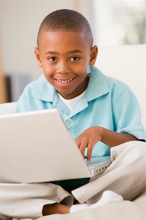 simsearch:400-04044137,k - Young boy in living room with laptop smiling Stock Photo - Budget Royalty-Free & Subscription, Code: 400-04044078