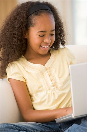 simsearch:400-04044108,k - Young girl in living room using laptop and smiling Stock Photo - Budget Royalty-Free & Subscription, Code: 400-04044073