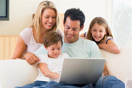 simsearch:400-04044134,k - Family in living room with laptop smiling Fotografie stock - Microstock e Abbonamento, Codice: 400-04044080