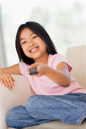 simsearch:400-04045202,k - Young girl in living room with remote control smiling Stock Photo - Budget Royalty-Free & Subscription, Code: 400-04044096