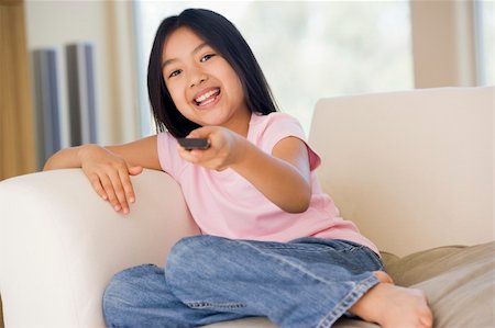 simsearch:400-04045202,k - Young girl in living room with remote control smiling Stock Photo - Budget Royalty-Free & Subscription, Code: 400-04044097