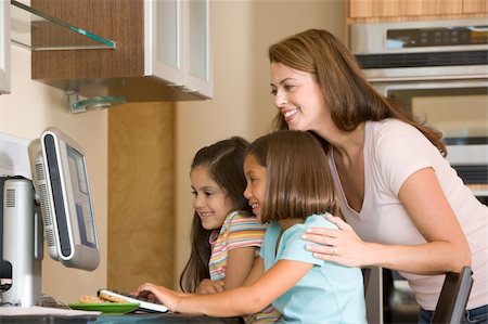 simsearch:400-04044108,k - Woman and two young girls in kitchen with computer smiling Stock Photo - Budget Royalty-Free & Subscription, Code: 400-04044104