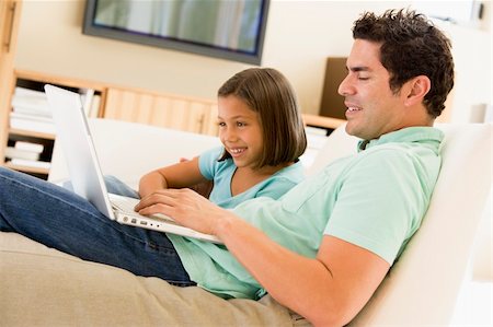 Man with young girl in living room with laptop smiling Stock Photo - Budget Royalty-Free & Subscription, Code: 400-04044106