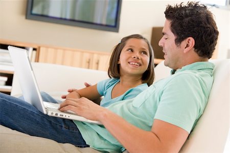 simsearch:400-04044134,k - Man with young girl in living room with laptop smiling Fotografie stock - Microstock e Abbonamento, Codice: 400-04044107