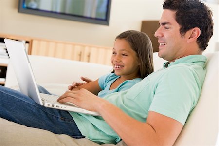 Man with young girl in living room with laptop smiling Stock Photo - Budget Royalty-Free & Subscription, Code: 400-04044108