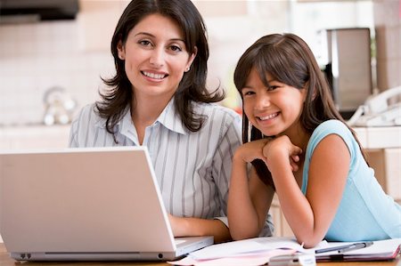 simsearch:400-04044137,k - Woman and young girl in kitchen with laptop and paperwork smilin Stock Photo - Budget Royalty-Free & Subscription, Code: 400-04044115