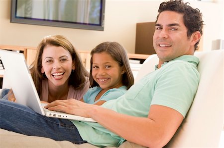 Family in living room with laptop smiling Foto de stock - Super Valor sin royalties y Suscripción, Código: 400-04044110