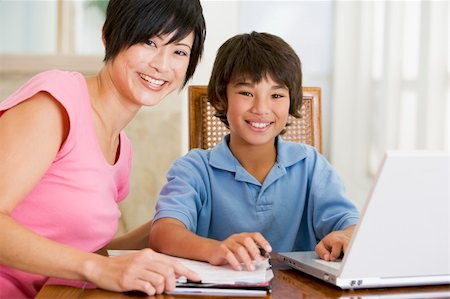 Woman helping young boy with laptop do homework in dining room s Stock Photo - Budget Royalty-Free & Subscription, Code: 400-04044134