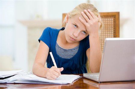 simsearch:400-04044137,k - Young girl with laptop doing homework in dining room looking unh Stock Photo - Budget Royalty-Free & Subscription, Code: 400-04044135