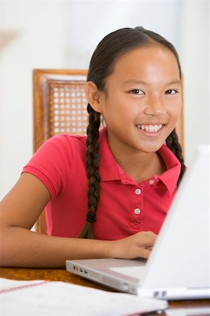 simsearch:400-04044137,k - Young girl with laptop in dining room smiling Stock Photo - Budget Royalty-Free & Subscription, Code: 400-04044130
