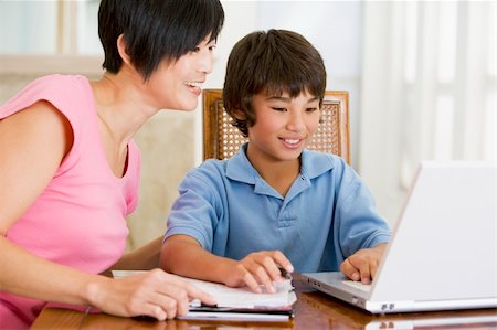 Woman helping young boy with laptop do homework in dining room s Stock Photo - Budget Royalty-Free & Subscription, Code: 400-04044133