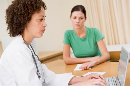 simsearch:400-04021788,k - Doctor using laptop with woman in doctor's office frowning Stock Photo - Budget Royalty-Free & Subscription, Code: 400-04044249