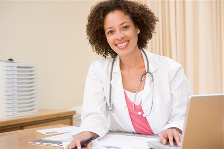 simsearch:400-04021788,k - Doctor with laptop in doctor's office smiling Stock Photo - Budget Royalty-Free & Subscription, Code: 400-04044285