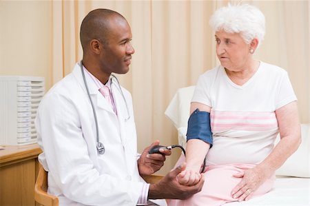 simsearch:400-04021788,k - Doctor checking woman's blood pressure in exam room Stock Photo - Budget Royalty-Free & Subscription, Code: 400-04044315