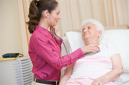 simsearch:400-05686822,k - Doctor giving checkup with stethoscope to woman in exam room smi Photographie de stock - Aubaine LD & Abonnement, Code: 400-04044317