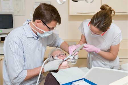 surgery tray - Dentist and assistant in exam room with woman in chair Stock Photo - Budget Royalty-Free & Subscription, Code: 400-04044354