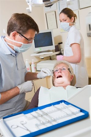 surgery tray - Dentist and assistant in exam room with woman in chair Stock Photo - Budget Royalty-Free & Subscription, Code: 400-04044352