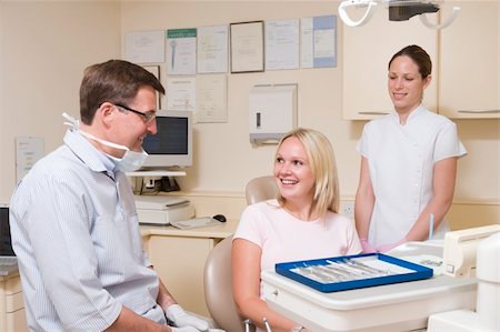 surgery tray - Dentist and assistant in exam room with woman in chair smiling Stock Photo - Budget Royalty-Free & Subscription, Code: 400-04044372