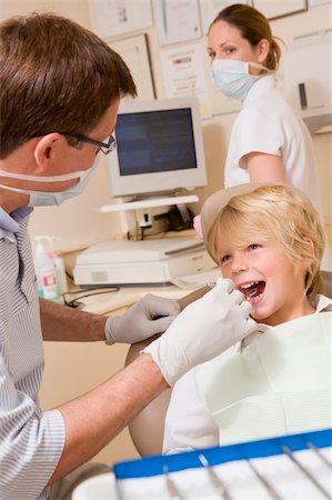 dentist tray - Dentist and assistant in exam room with young boy in chair Stock Photo - Budget Royalty-Free & Subscription, Code: 400-04044381