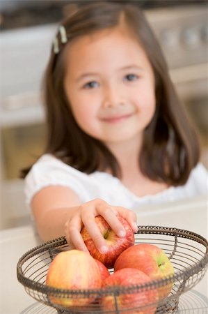 simsearch:400-04044645,k - Girl taking apple from fruit basket at home Photographie de stock - Aubaine LD & Abonnement, Code: 400-04044676