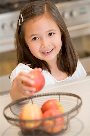 simsearch:400-04044645,k - Girl taking apple from fruit basket at home Photographie de stock - Aubaine LD & Abonnement, Code: 400-04044677