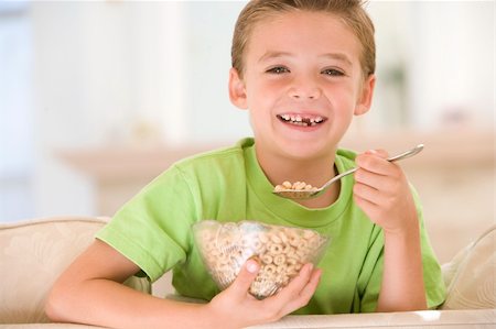 simsearch:400-04044761,k - Young boy eating cereal in living room smiling Foto de stock - Super Valor sin royalties y Suscripción, Código: 400-04044718