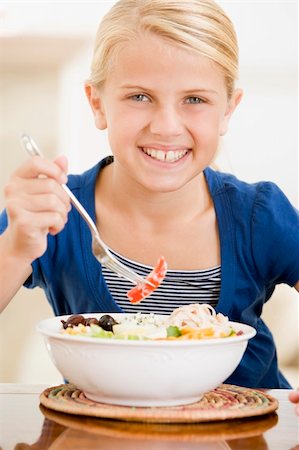 simsearch:400-04044645,k - Young girl indoors eating seafood smiling Photographie de stock - Aubaine LD & Abonnement, Code: 400-04044769