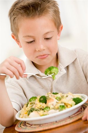 Young boy indoors eating pasta with brocolli. Stock Photo - Budget Royalty-Free & Subscription, Code: 400-04044762