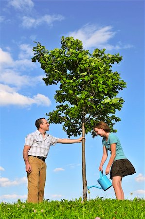 simsearch:400-03915968,k - Father and daughter watering a young tree Photographie de stock - Aubaine LD & Abonnement, Code: 400-04044882