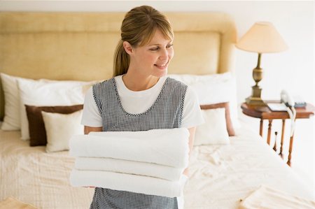 Maid holding towels in hotel room smiling Stock Photo - Budget Royalty-Free & Subscription, Code: 400-04045022