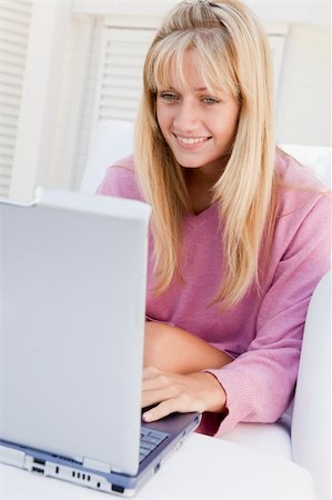 Woman on patio using laptop smiling Photographie de stock - Aubaine LD & Abonnement, Code: 400-04045129